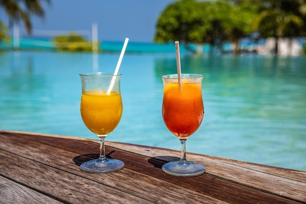 Zwei Cocktails tropisches Luxus-Strandresort. Paarurlaub, Reiseurlaub, Sommerinsel am Pool