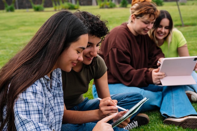 Zwei College-Studenten mit einem Tablet auf dem Campus-Gras