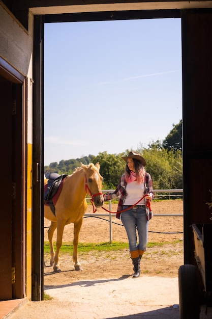 Zwei Cowgirl-Frauen genießen mit einem Pferd beim Reiten, mit südamerikanischen Outfits