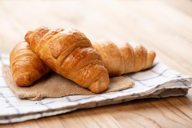 Zwei Croissants sind auf dem Teller Croissant ist ein butterartiges, flockiges französisches Gebäck. Dieses Brot verwendet den französischen Blätterteig mit Hefe. Knusprig und lecker