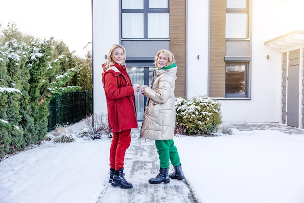 Zwei Damen posieren vor dem Haus für die Kamera