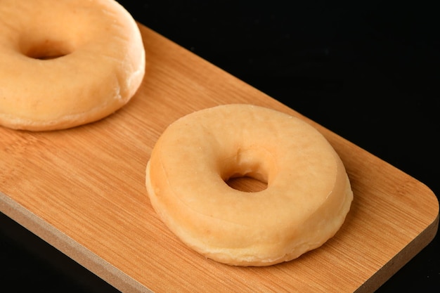 Zwei Donuts auf einem Holzbrett