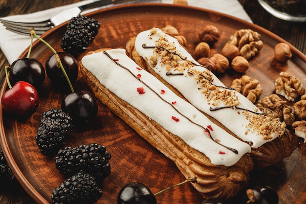 Zwei Eclairs mit Beeren und Nüssen