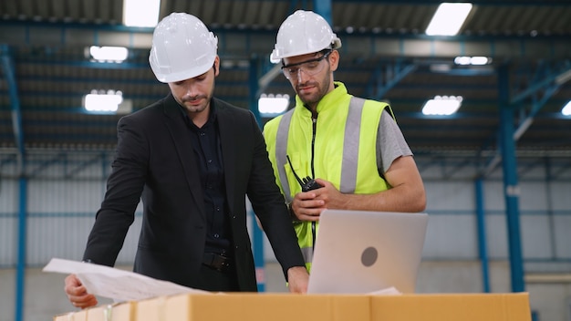 Zwei Fabrikarbeiter arbeiten und besprechen den Fertigungsplan in der Fabrik. Industrie- und Technikkonzept.