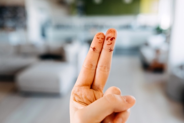 Zwei Finger mit gezeichneten Gesichtern, die sich umarmen.