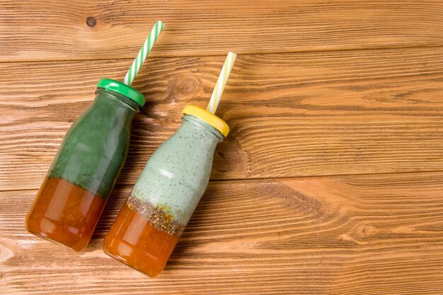 Zwei Flaschen Superfood Spirulina Seetang trinken auf einem Holztisch.