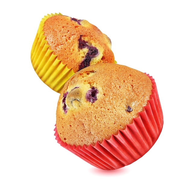 Zwei fliegende Muffins mit Beeren in einem Backpapierbecher. Auf Weiß isoliert. Alles im Fokus