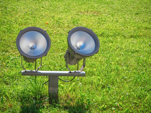 Zwei Flutlichter auf einem grünen Rasen. Der Scheinwerfer ist auf einer grünen Wiese installiert. Nahansicht.