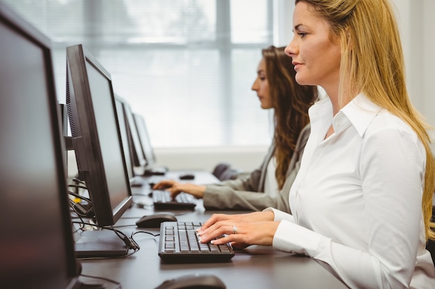 Zwei fokussierte Frauen, die im Computerraum arbeiten