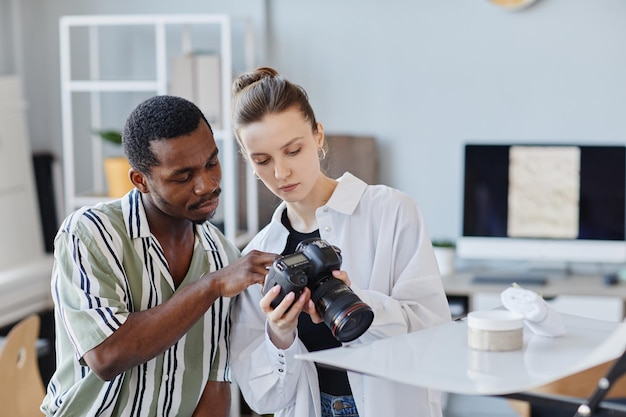 Zwei Fotografen, die Bilder in der Kamera auswählen