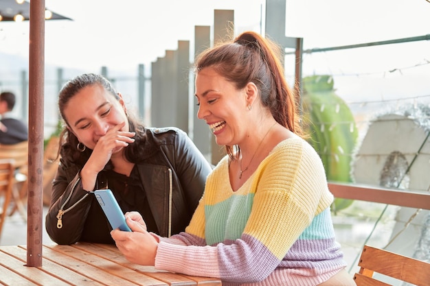 Foto zwei frauen amüsieren sich gemeinsam im restaurant im freien