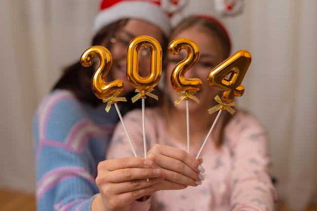 Zwei Frauen, die 2024 halten. Nummer für das neue Jahr.