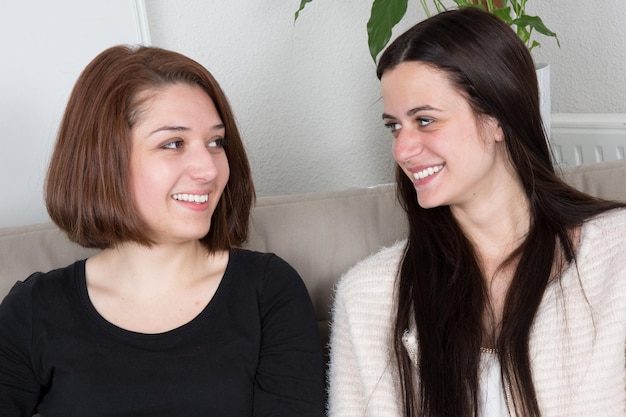 Zwei Frauen, die einander anschauen, gute Freunde oder Schwestern, auf der Couch