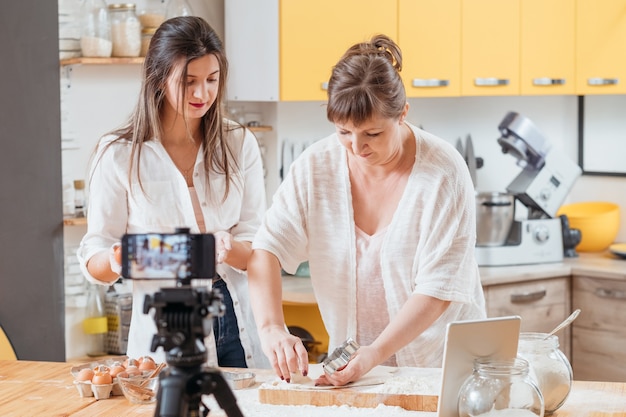Zwei Frauen, die Kochprozess auf Smartphone filmen