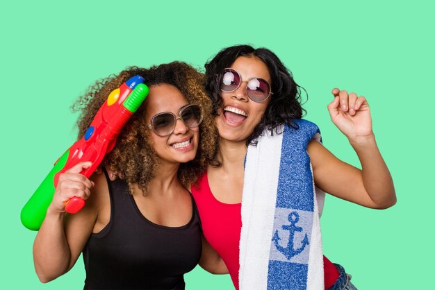 Zwei Frauen, eine mit Afro-Haaren und die andere Latina, sind bereit für einen Strandurlaub in Badekleidung