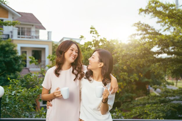 Zwei Frauen entspannen auf dem Dachgarten und trinken Kaffee