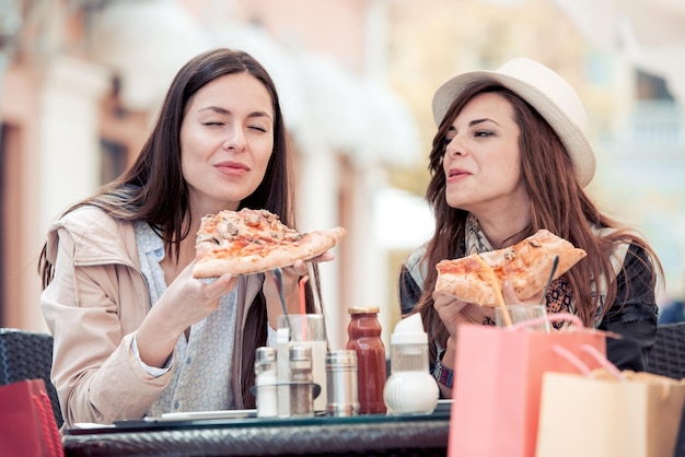 Zwei Frauen haben Spaß daran, gemeinsam Pizza zu essen