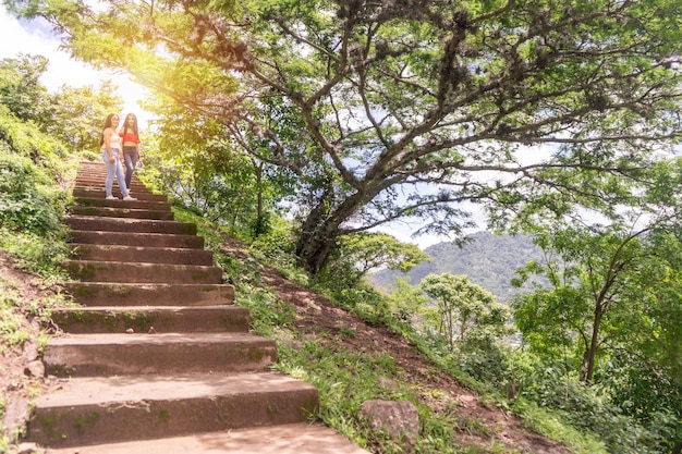 Zwei Frauen im Teenageralter am oberen Ende der Treppe in einer bergigen Gegend