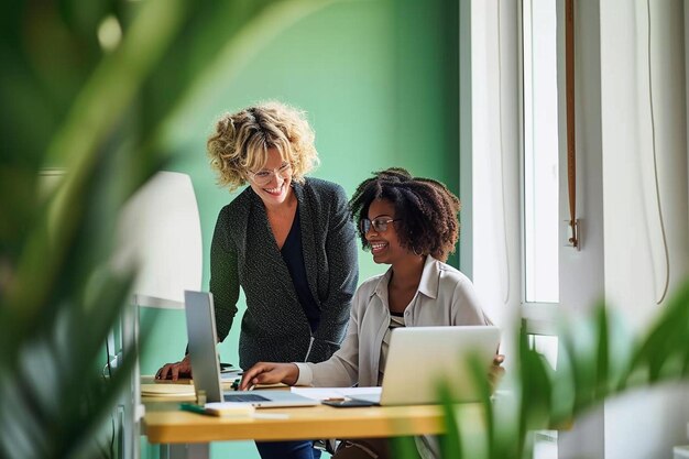 Foto zwei frauen sitzen an einem tisch und arbeiten an einem laptop