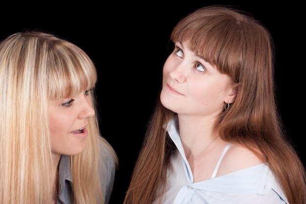 Foto zwei frauen sprechen vor einem schwarzen hintergrund