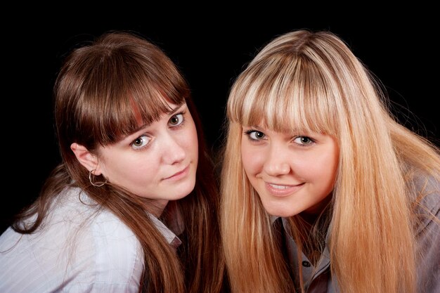 Foto zwei frauen vor einem schwarzen hintergrund, von denen eine ein weißes hemd hat