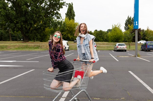 Zwei Freunde, die Spaß auf einem Supermarktparkplatz haben