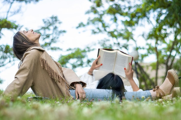 Zwei Freunde genießen einen gemeinsamen Tag im Park, schnappen frische Luft und lesen ein Buch