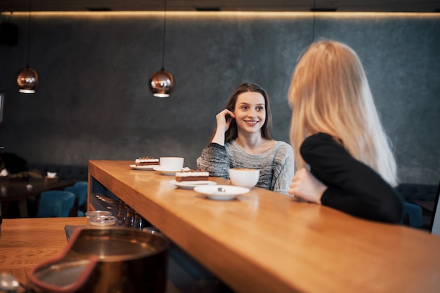 Zwei Freunde genießen gemeinsam Kaffee in einem Café, während sie an einem Tisch sitzen und sich unterhalten