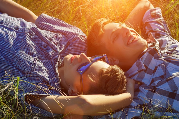 Foto zwei freunde liegen auf dem gras