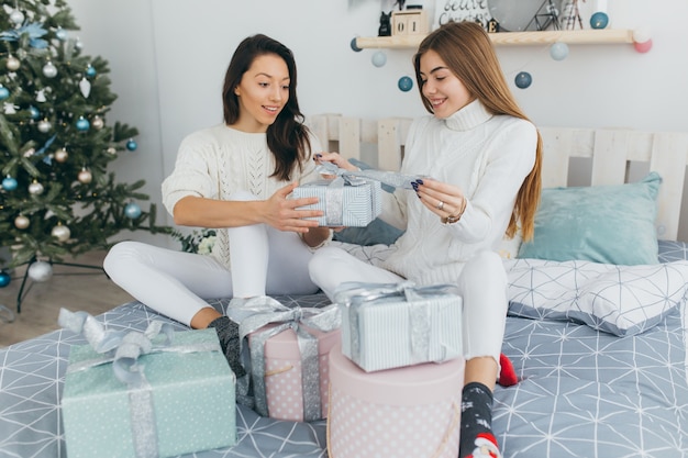 Zwei Freunde öffnen Weihnachtsgeschenke.