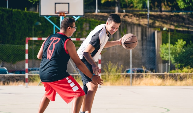 Zwei Freunde spielen Basketball auf einer Straßenbahn