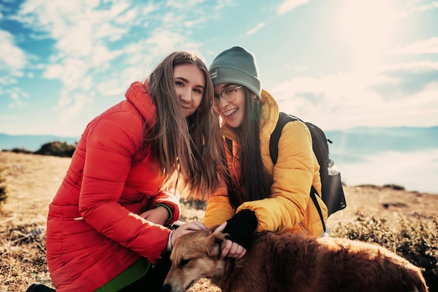 Zwei Freunde spielen mit einem Hund in der Natur