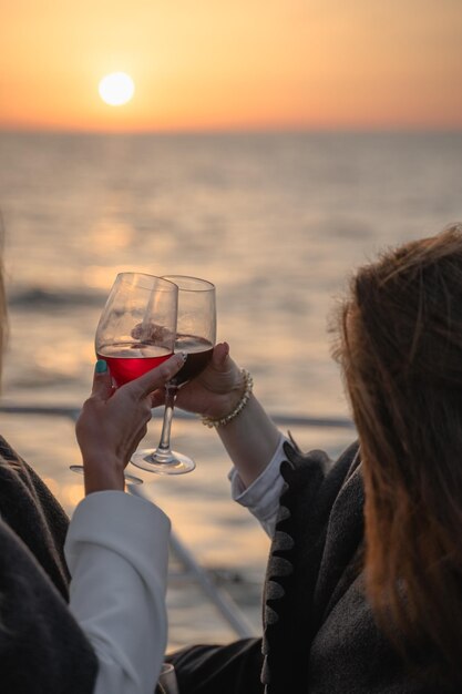 Zwei Freunde stoßen während des Sonnenuntergangs auf einer Yacht mit Wein an