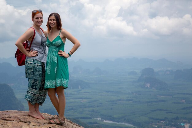 Zwei Freunde werden auf dem Hintergrund des Aussichtspunkts fotografiert Blick auf das Tal und die Inseln und Berge der Andamanensee vom Aussichtspunkt Krabi Thailand