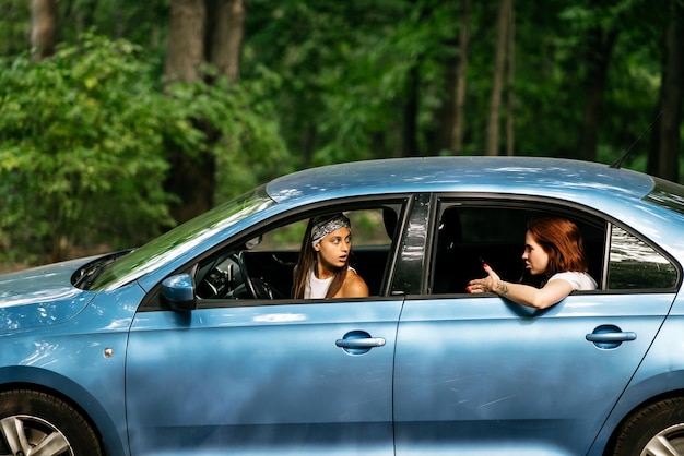 Zwei Freundinnen albern herum und lachen zusammen in einem Auto