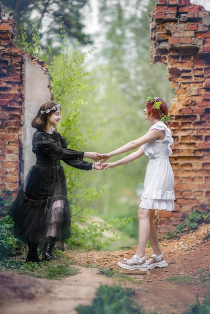 Foto zwei freundinnen drehen händchen haltend in der natur