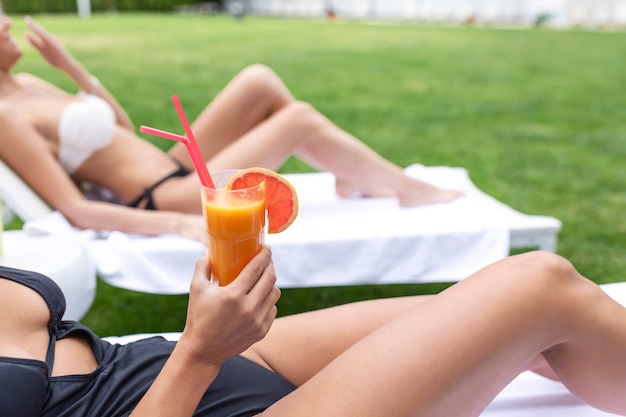 Zwei Freundinnen im Spa-Resort verbringen Sommerferien mit einem Cocktail.