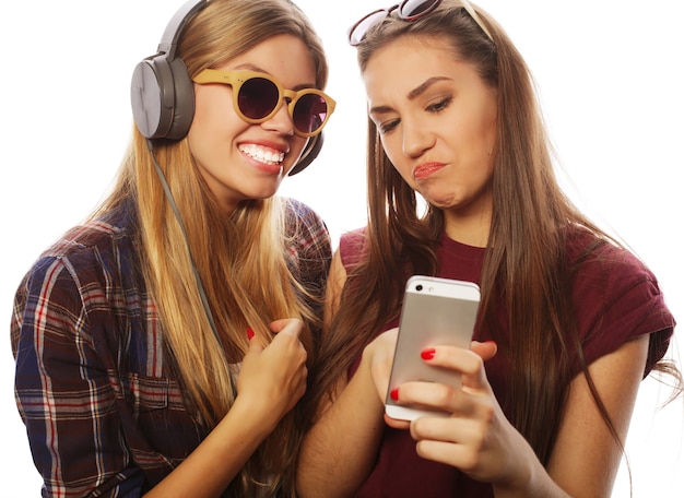 Zwei Freundinnen im Teenageralter im Hipster-Outfit machen Selfie auf einem Telefon.