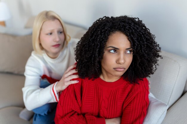 Zwei Freundinnen sitzen auf dem Sofa und streiten miteinander