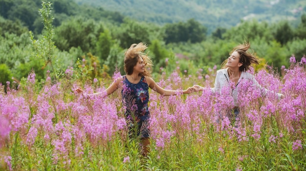 Zwei Freundinnen Sorgloses lesbisches Mädchen sonniger Parknatur-Landschaftshintergrund