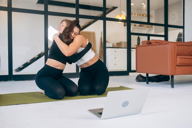 Zwei Freundinnen umarmen sich nach dem Yoga