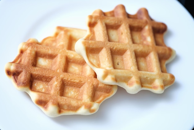 Zwei frisch gebackene belgische Waffeln auf weißer Platte