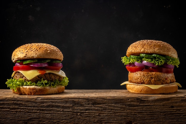 Zwei frische leckere Burger auf rustikalem Holztisch.