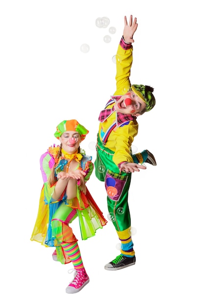 Foto zwei fröhliche clowns freuen sich über die seifenblasen auf weißem hintergrund