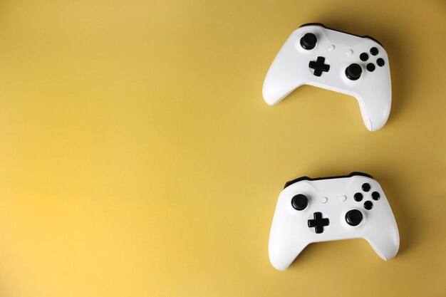 Zwei Gaming-Gamepads an der Seite auf einem isolierten gelben Hintergrund