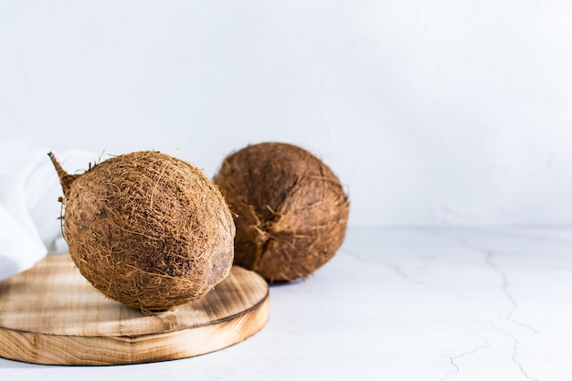 Zwei ganze reife Kokosnüsse auf dem Tisch Tropische Früchte