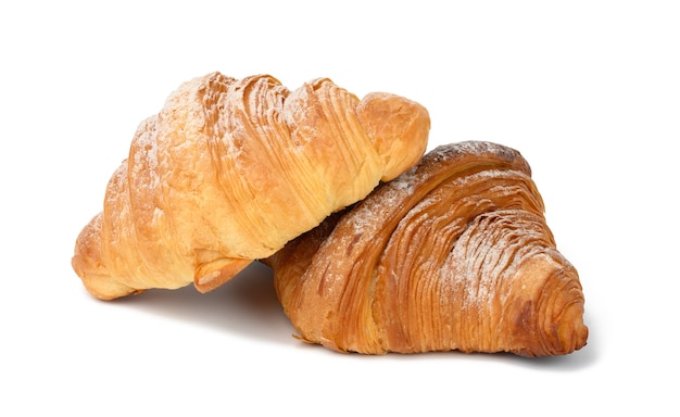 Zwei gebackene Croissants auf weißem, isoliertem Hintergrund, Dessert zum Frühstück mit Puderzucker bestreut