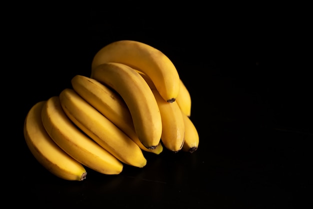 Zwei gelbe Bananen auf dem schwarzen Hintergrund