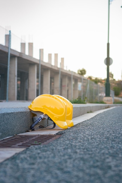 Zwei gelbe Helme thronten auf dem Bürgersteig mit einer Baustelle im Hintergrund