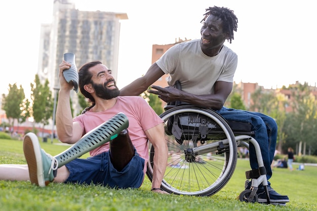 Foto zwei gemischtrassige freunde mit behinderungen scherzen und lachen über menschen mit persönlichem und innerem erfolg, beispiele für entschlossenheit und vitalität